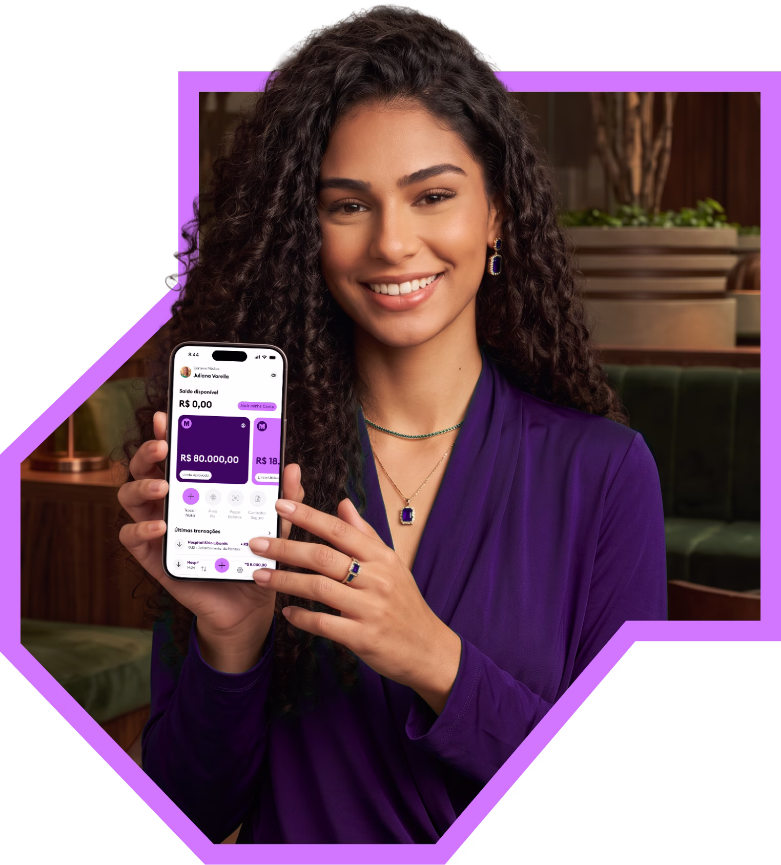 Médica sorrindo segurando o celular com o app da Medcred aberto